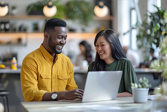 A couple smiling using a laptop